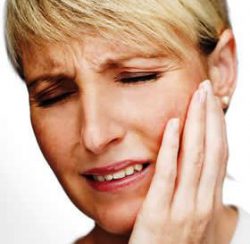 Woman holding her jaw in pain